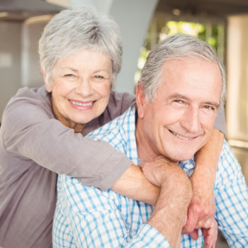 Senior couple smiling together in a close embrace.