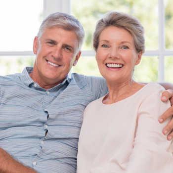 Smiling senior couple sitting together indoors.