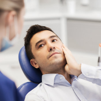 Man receiving a dental check-up from a dentist.
