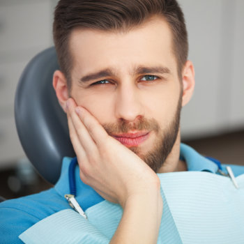 Man with toothache sitting in a dental clinic.
