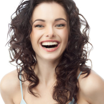 Woman with curly hair smiling against a white background.