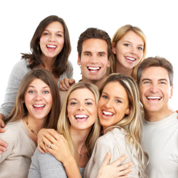 A group of happy adults embracing and smiling at the camera.