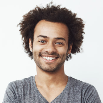 A smiling man with curly hair against a white background.