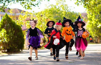 kids trick or treat on suburban street